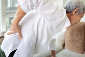 Sad asian senior woman with back and hip joint painful while sta